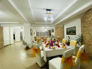 a dining room with a long table and chairs at PASTRAVARIA ALINA in Sîrbi