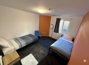 una camera d'albergo con due letti e una scrivania di Big Backpackers Hostel a Sydney Altre 28 foto
