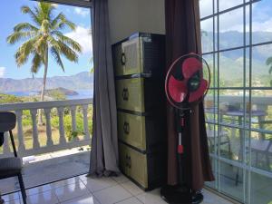 a room with a fan in front of a window at Hiva Oa Villa Lodge in Hiva Oa