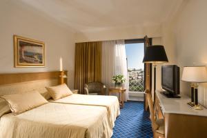 Posteľ alebo postele v izbe v ubytovaní Royal Olympic Hotel