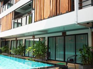 a hotel with a swimming pool in front of a building at Lanna Tree Boutique Hotel in Chiang Mai