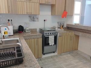 a kitchen with a stove and a sink at Casa Marabella C3 in Diani Beach