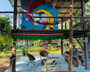 a building with chairs and a mural on it at Latehouse bar Amphawa in Amphawa