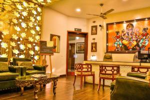 ジャイプールにあるHotel Pearl Palace Jaipurのリビングルーム(ソファ、椅子、テーブル付)