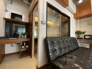 a black leather couch in a room with a kitchen at Lanna Tree Boutique Hotel in Chiang Mai