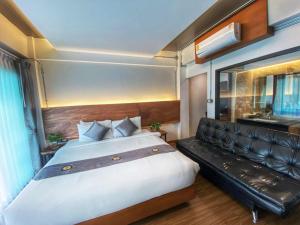 a bedroom with a large bed and a couch at Lanna Tree Boutique Hotel in Chiang Mai