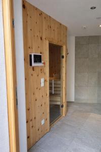 a room with a wooden wall with a microwave on it at Kramerl in Bruck an der Großglocknerstraße