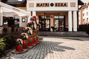 a row of fire hydrants in front of a store at Matrioszka Pokoje Hotelowe in Gołdap