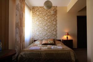 a bedroom with a bed with a window and a curtain at Matrioszka Pokoje Hotelowe in Gołdap