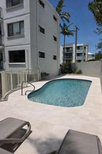 a swimming pool in front of a building at Pleasant View Apartment - Ocean View in Caloundra
