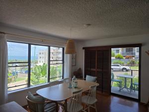 a living room with a table and a large window at Pleasant View Apartment - Ocean View in Caloundra