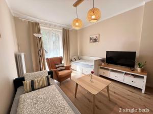 a living room with a couch and a flat screen tv at Akacja Centrum Apartament in Rzeszów +17 photos
