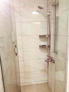 a shower with a glass door in a bathroom at Maizi Apartment Homestay, Shanghai in Shanghai