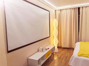 a room with a large projection screen on the wall at Maizi Apartment Homestay, Shanghai in Shanghai