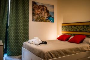 a bedroom with a bed with two red pillows at B&B Luxury Salerno Central in Salerno