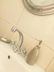 La salle de bains est pourvue d'un lavabo, d'un robinet et d'un miroir. dans l'établissement Holiday Home Villa Monica, à Koreniki