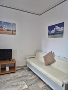 a white room with a bed and a tv at Varmy in Ierapetra