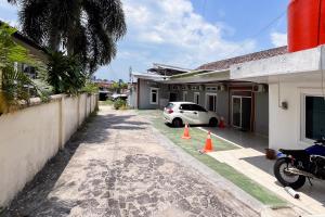 a car parked in front of a house with orange cones at Kostel 99 Pangkal Pinang RedPartner in Pangkal Pinang