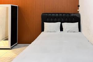 a bed with a black headboard in a room at Kostel 99 Pangkal Pinang RedPartner in Pangkal Pinang +16 photos