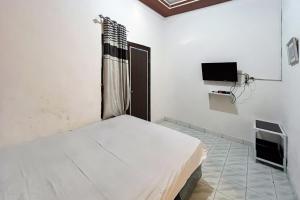 a hospital room with a bed and a tv at Kostel 99 Pangkal Pinang RedPartner in Pangkal Pinang