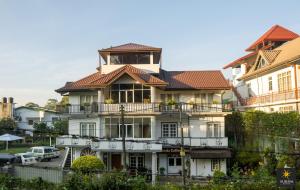a large white house with a red roof at Suriya Guest in Nuwara Eliya