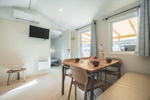 a dining room with a wooden table and chairs at Camping Le Malazéou Wellness Sport Camping in Ax-les-Thermes