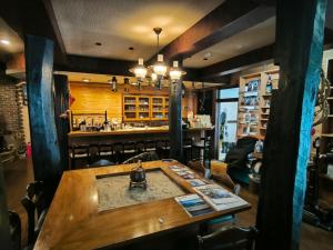 a restaurant with a wooden table and a bar at A Lucky Hostel in Hakuba