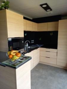 a kitchen with a bowl of fruit on a counter at Charmant Cottage in Saubrigues