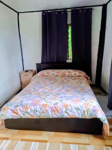 a bed in a room with purple curtains and a bed with a bedspread at LOwayalailaiSTAY in Wayasewa Island