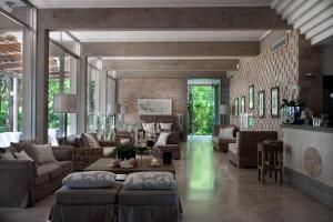 a living room with couches and tables and a brick wall at Hotel Mediterraneo Suite&Residence in Lido di Jesolo