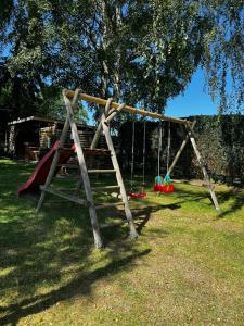 a swing set in a park with a tree at Ostsee Pension Pohnsdorfer Mühle in Sierksdorf