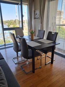 a table and chairs in a room with a large window at Dunai panoráma in Budapest