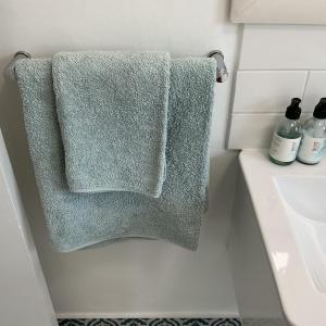 a green towel hanging on a towel rack in a bathroom at Bella Vista Lago in Marina da Gama +24 photos