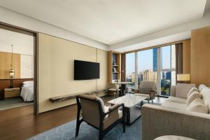 a hotel room with a couch and a tv at Xi'an Marriott Hotel High-Tech Zone in Xi'an