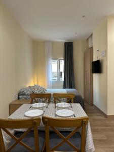 a room with a table and chairs and a bed at ARBE Apartamentos in Bilbao
