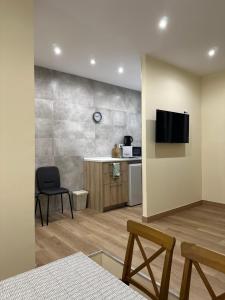 a room with a kitchen and a table and a television at ARBE Apartamentos in Bilbao