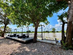a picnic area next to a river with trees at Sai Klong Song Lae Resort Pakpra Phatthalung in Phatthalung