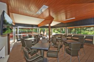 ein Restaurant mit Holzdecken und Tischen und Stühlen in der Unterkunft Happy Camp mobile homes in Villaggio Camping Baia Domizia in Baia Domizia