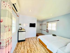 a bedroom with a large bed and a kitchen at Sai Klong Song Lae Resort Pakpra Phatthalung in Phatthalung
