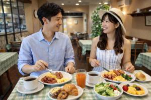 a man and woman sitting at a table with plates of food at ホテルサンモール in Asahi
