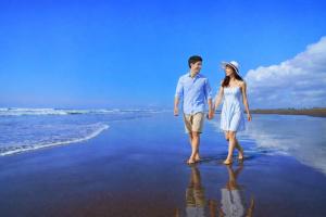 a man and a woman standing on the beach at ホテルサンモール in Asahi