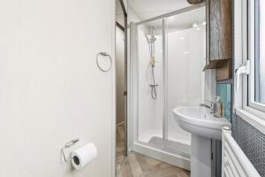 a white bathroom with a sink and a shower at Harbour View at Avocet Crescent - Luxury Lodge with Hot Tub - Hayling Island - Mill Rythe Holiday Village in North Hayling +13 photos