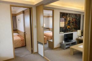 a hotel room with two beds and a television at ホテルサンモール in Asahi