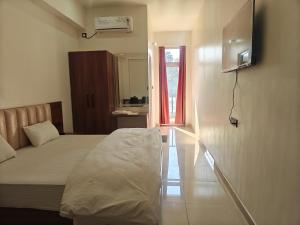 a bedroom with a bed and a tv on a wall at Hotel Nandaashish in Haldwāni