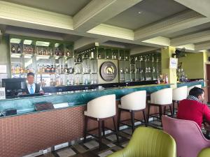 a bar in a restaurant with people sitting at it at Hotel Nandaashish in Haldwāni