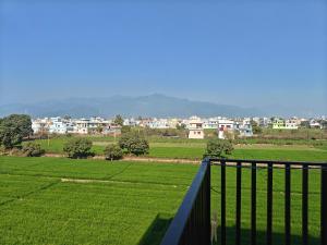 a balcony with a view of a green field at Hotel Nandaashish in Haldwāni