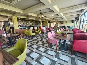 a restaurant with tables and chairs and a bar at Hotel Nandaashish in Haldwāni