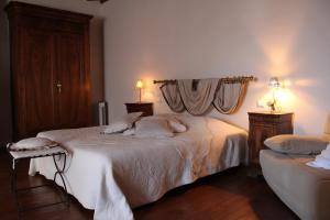 um quarto com uma cama branca e 2 candeeiros em La Maison d'Anais em Vic-en-Bigorre