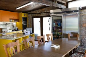 a kitchen with a table and chairs and a refrigerator at The Bird Villa in Bosnek