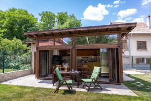 a pavilion with a table and chairs in a yard at The Bird Villa in Bosnek